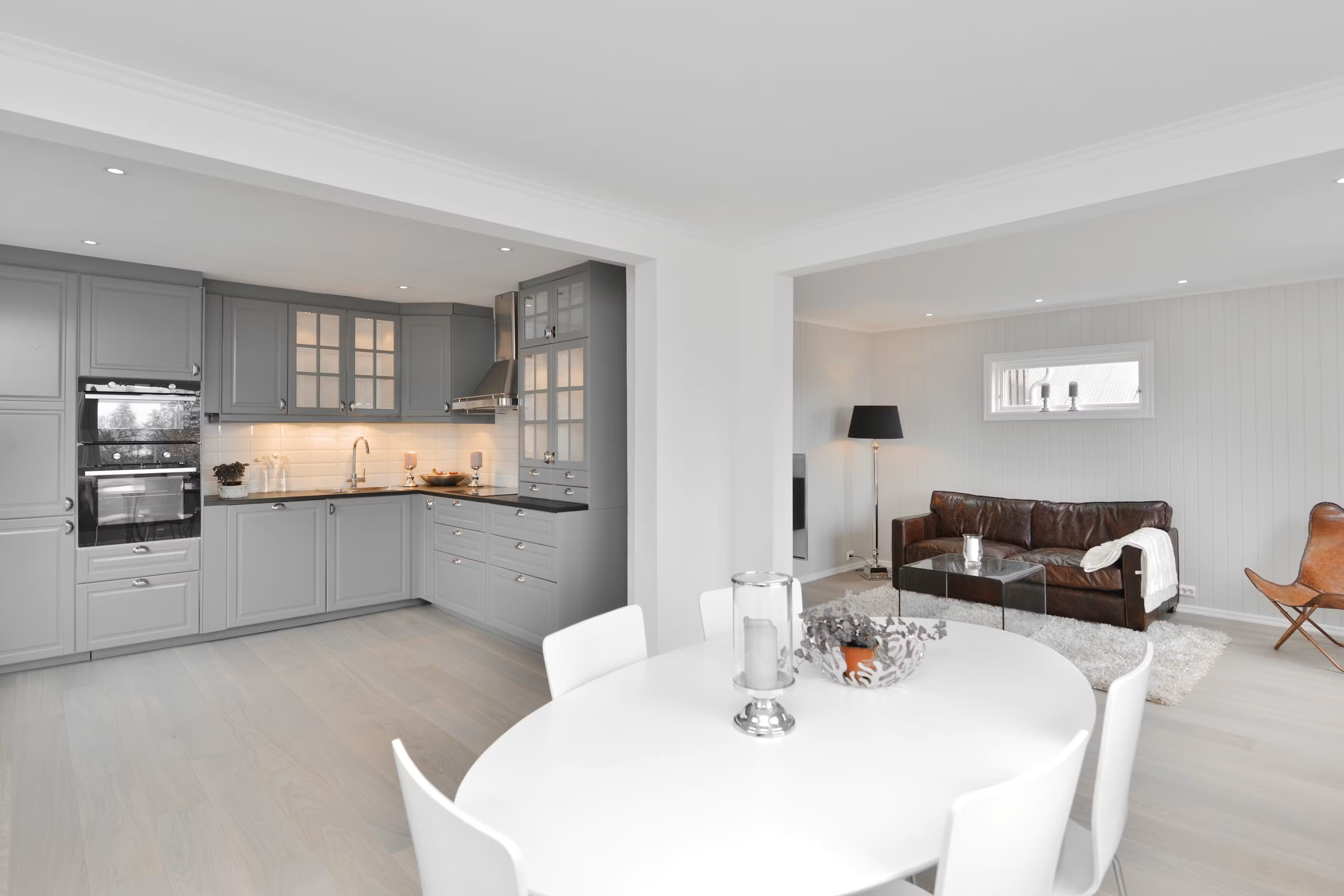 Oversiktsbilde fra totalrenovert enebolig på Gjøvik – spisestue, kjøkken og sofakrok i åpen og lys planløsning, utført av Mjøsbygg