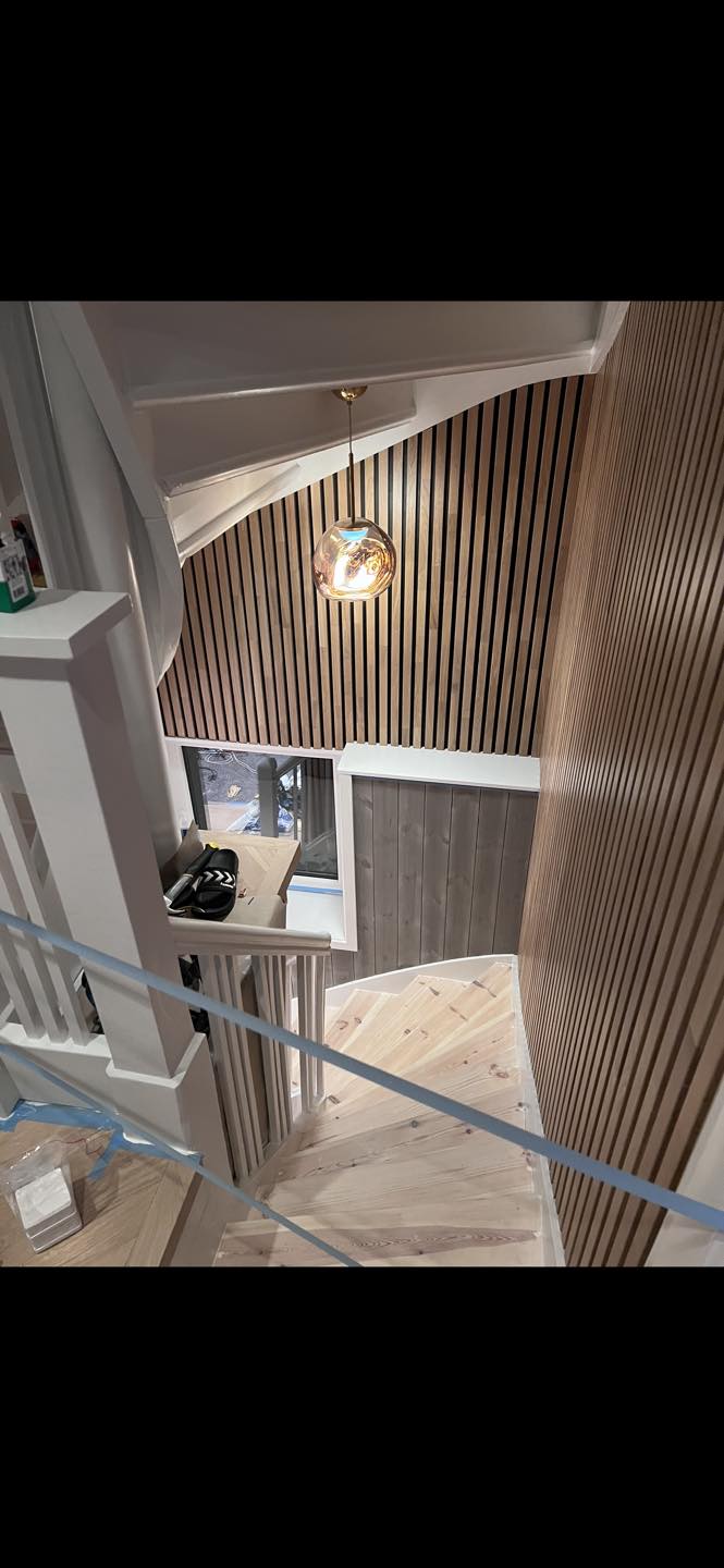 Ferdig oppusset trappegang med moderne spilevegger, stilrene lamper, lyse tregulv og nytt gelender – utført av Mjøsbygg