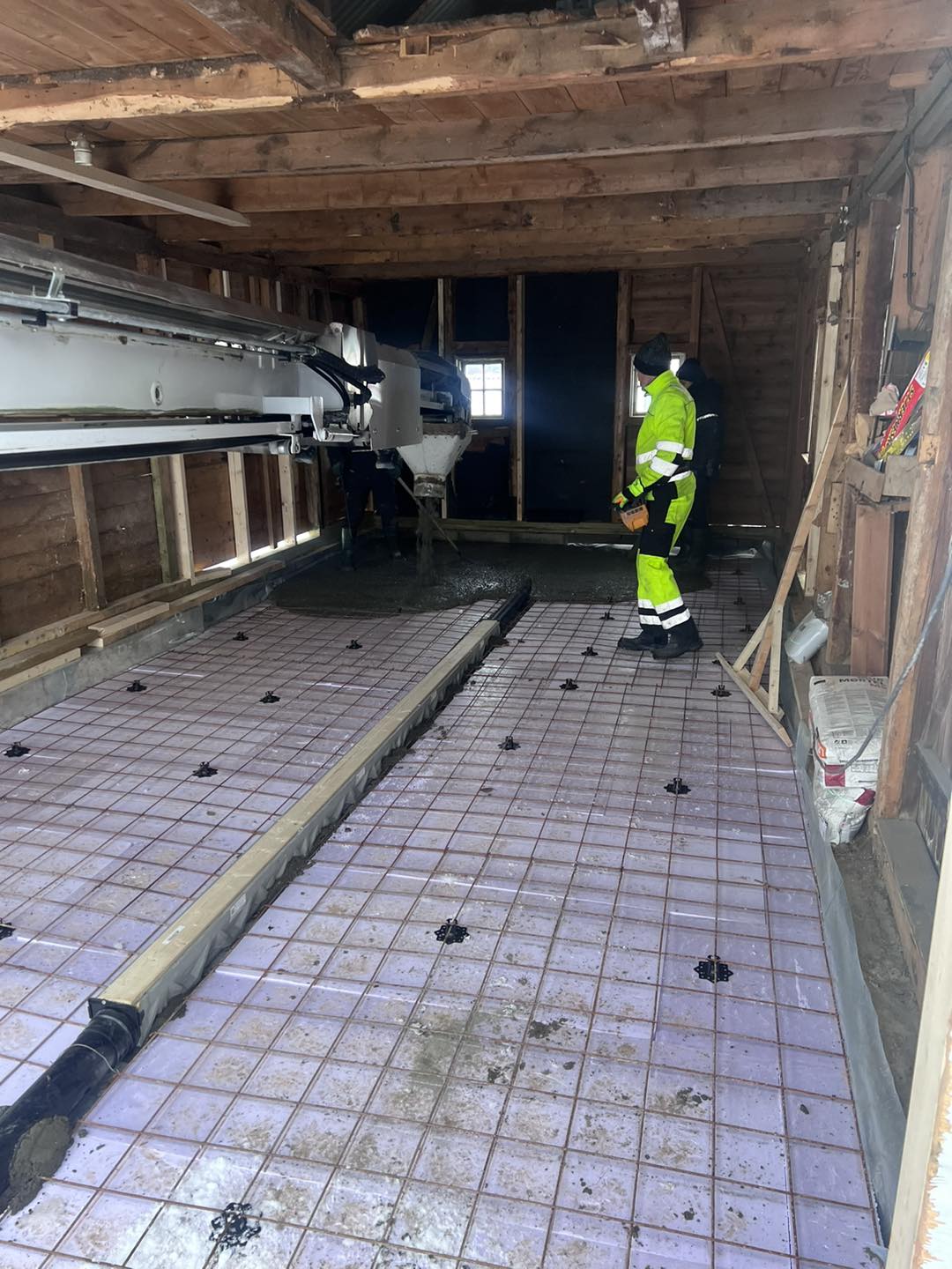 Støping av garasjegulv i Gjøvik – fersk betong fordeles og glattes ut av håndverker fra Mjøsbygg under garasjebygging