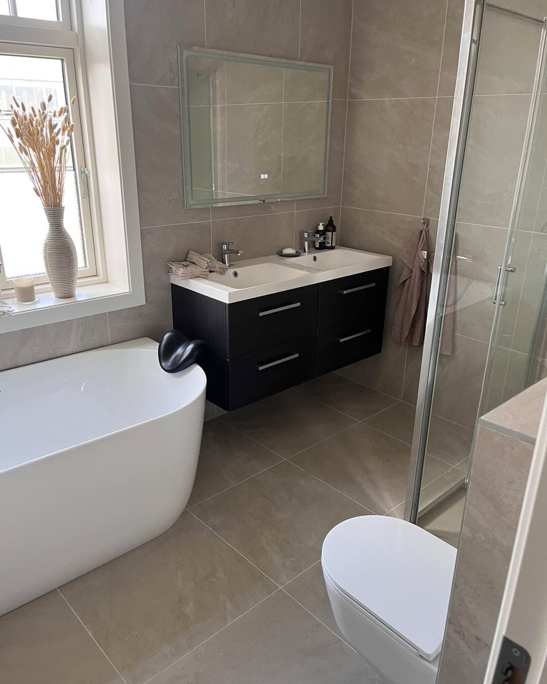 Totalrenovert bad med frittstående badekar, dusj, vegghengt toalett og dobbel servant – utført av Mjøsbygg