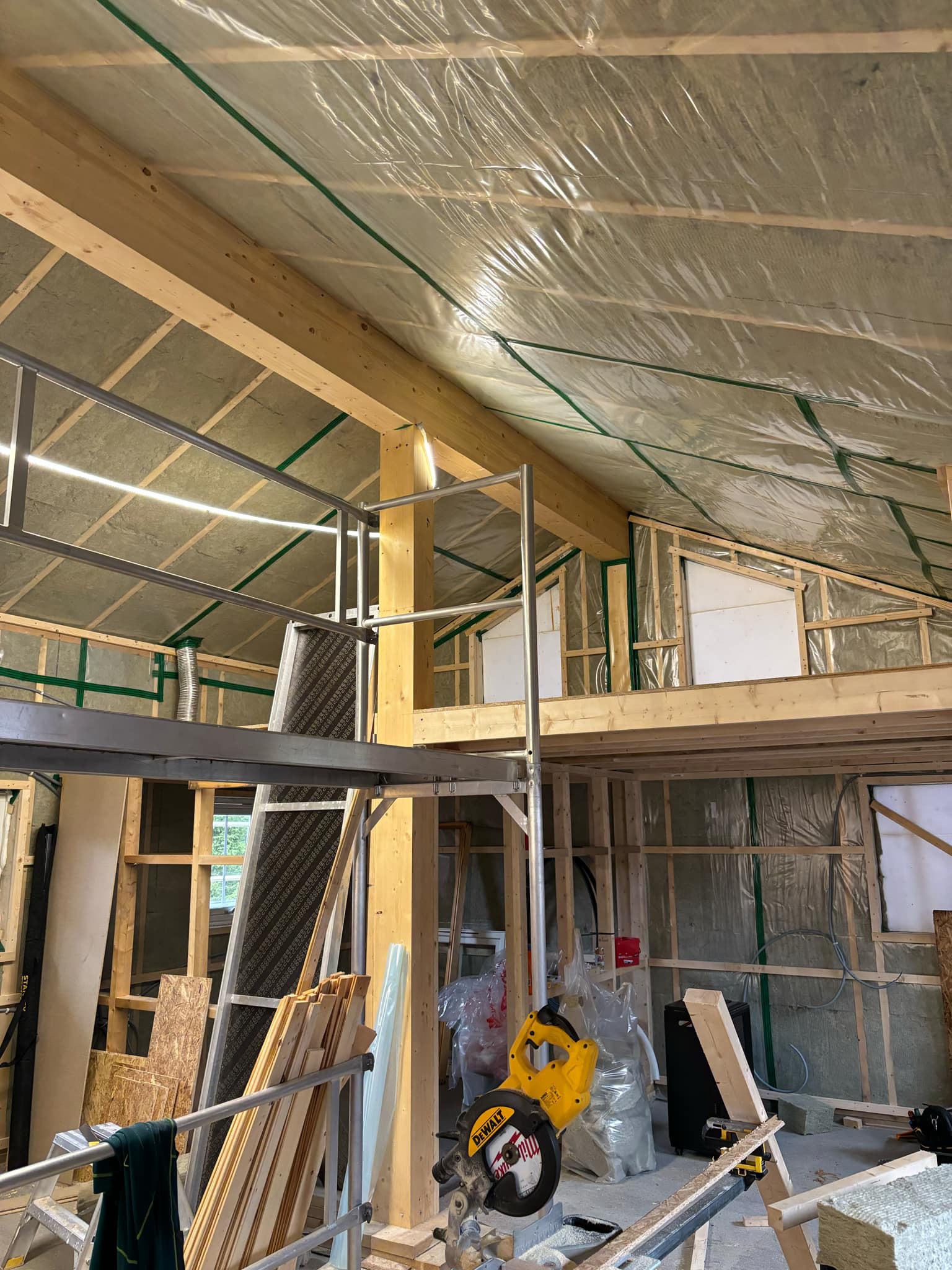 Innvendig bilde fra tilbygg på hytte i Sjusjøen – konstruksjon med synlig isolasjon og bærestolper, arbeid utført av Mjøsbygg